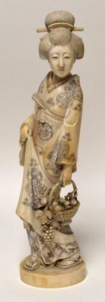 null Grand OKIMONO en ivoire sculpté, Geisha tenant un panier de fruits. Signé sous...