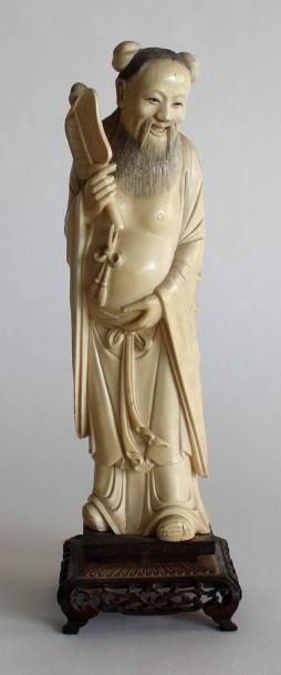 null SAGE en ivoire sculpté, tenant un éventail. Chine, vers 1930. H. 27 cm. Poids...