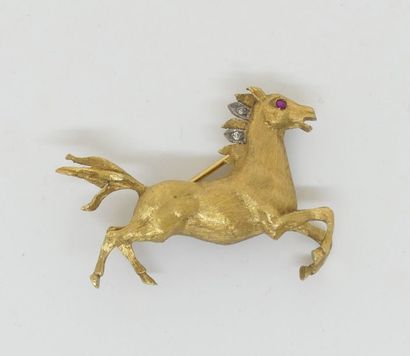 null BROCHE figurant un cheval au galop, en or jaune brossé, les yeux sertis de rubis,...