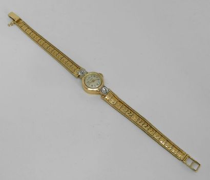 null MONTRE BRACELET de dame en or jaune, le boitier rond accosté de deux diamants...