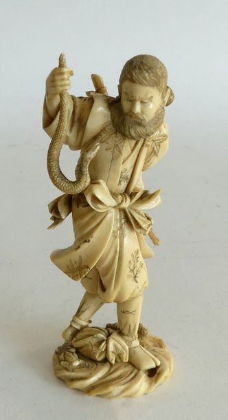 null OKIMONO en ivoire figurant un homme armé d'un baton capturant un serpent. Japon,...