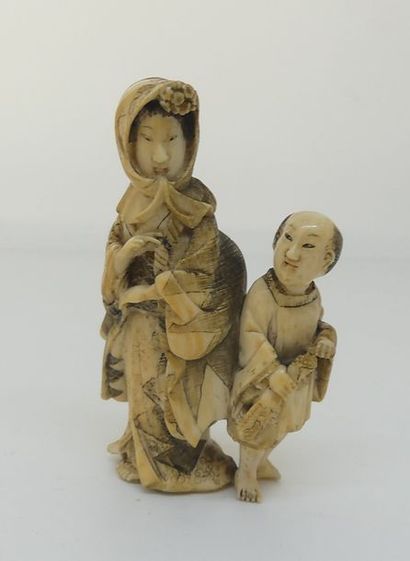 null GROUPE en ivoire à patine noire et or: Femme et enfant. Signé. Japon XIXe. H....