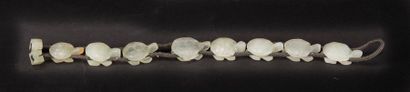 null CHINE, XXème siècle. Huit perles tortues en jade néphrite enfilées sur un cordon...