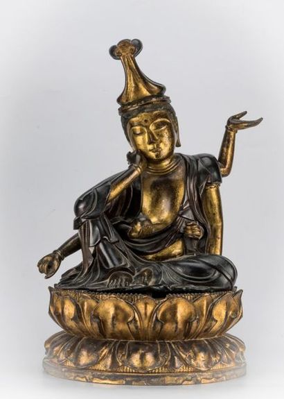 null JAPAN. Kannon sitting in gold lacquered bronze, resting on a lotiform base in...