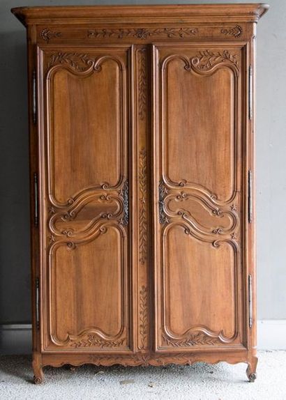null Walnut wardrobe molded and carved with flowers, foliage and stars opening at...