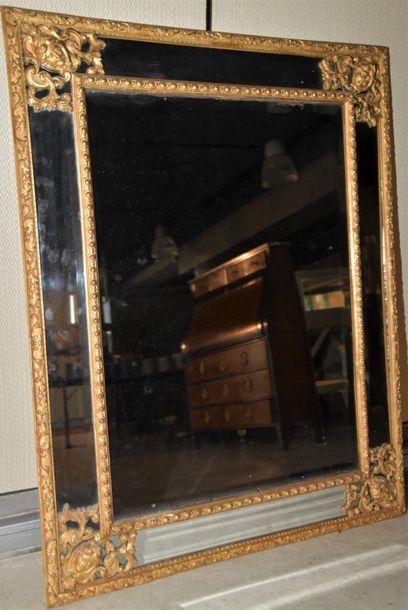 null Miroir à pareclose en bois et stucs doré, à décor de têtes de personnages et...