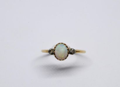 null Ring in 750°/00 yellow gold set with a large oval opal cabochon, surrounded...