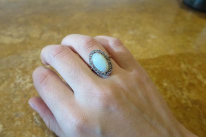 null Ring in 750°/00 yellow gold set with a large oval opal cabochon, surrounded...