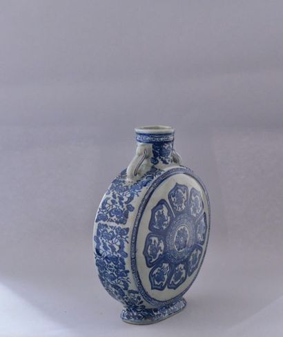 null Chine, XXème siècle. Vase gourde en porcelaine bleu blanc à décor d’emblèmes...