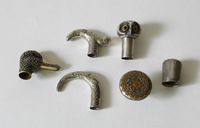 null Two silver cane pommels including: 
- an owl's head pommel, black and amber...