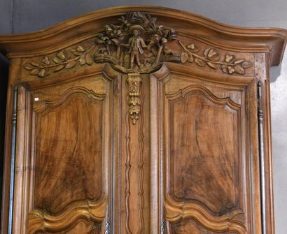 null *A carved and moulded walnut cabinet, the pediment carved with a peasant, trees...