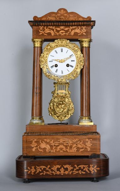 null Portico clock in light wood marquetry with floral scrolls decoration. The enamelled...