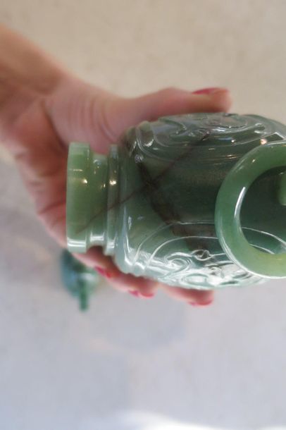 null Chine XXe. Vase couvert en jade néphrite à décor de dragons retenant des anneaux....