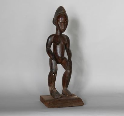 null COTE D'IVOIRE 

Statue féminine en bois à patine rougeâtre. 

XXe, dans le style...