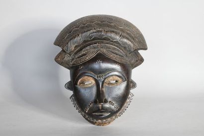 null COTE D'IVOIRE 

Masque en bois sculpté à patine noire. 

XXe, de style BAOULE...