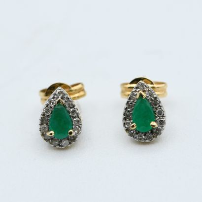 null Pair of drop-shaped earrings adorned with two emeralds in a diamond surround....