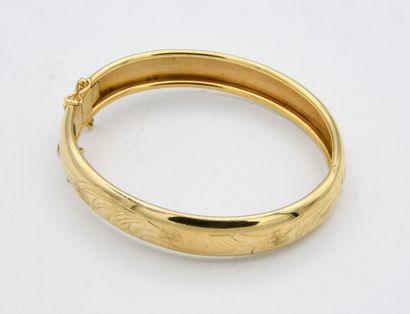 null *Bracelet jonc en or jaune 18 carats (750 millièmes) gravée de rinceaux feuillagés.
Chaînette...