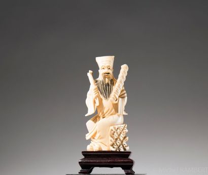 CHINE Personnage assis, sujet en ivoire sculpté sur socle en bois. H: 14 cm