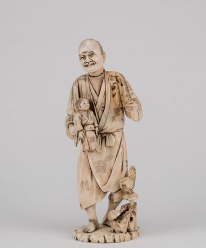 null Japon, début XXème siècle.. Groupe en ivoire sculpté représentant un marionnettiste...