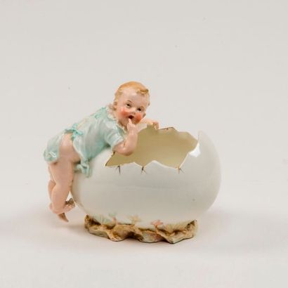 null Sujet en porcelaine polychrome. Bébé sur un œuf. L : 16 cm.