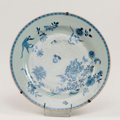 null Chine. Grand plat en porcelaine à décor bleu et blanc de fleurs. XIXème siècle....