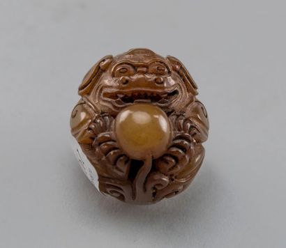 null CHINE, XXème siècle. Pendentif en agate à décor sculpté d'un lion bouhique tenant...