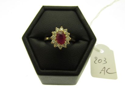 null 1 gold setting ring decorated with a ruby (treated) in a circle of small diamonds,...