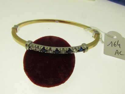1 bracelet rigide ouvrant de section carrée monture or deux tons orné d'une ligne de pierres, bossué PB 12,3g AC