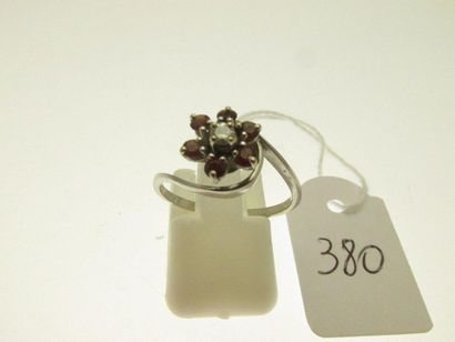 1 bague monture or gris sertie d'un petit diamant dans un entourage de petits rubis, bossuée TDD 54 PB 2,3g