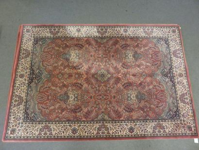 * Tapis Mechanical carpet with red background and beige border. 200x300 cm