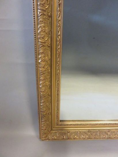 * Miroir Grand miroir rectangulaire à cadre feuillagé en bois et stuc doré. 140x110...