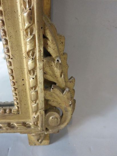 GLACE Glace ancienne en bois doré et sculpté de style Louis XVI (accidents et manques)....