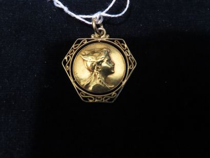 * Médaille 
Médaille de baptême en or à profil de femme casquée et à monture ajourée....