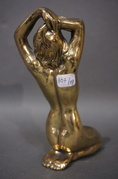 null "Femme nue accroupie" en métal doré. 16 cm