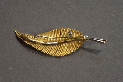 Broche Gold brooch in the shape of a leaf set with a diamond and five small emeralds...