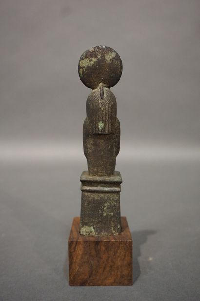 null Anthropomorphic statuette with a hawk's head wearing a solar disk and a striated...