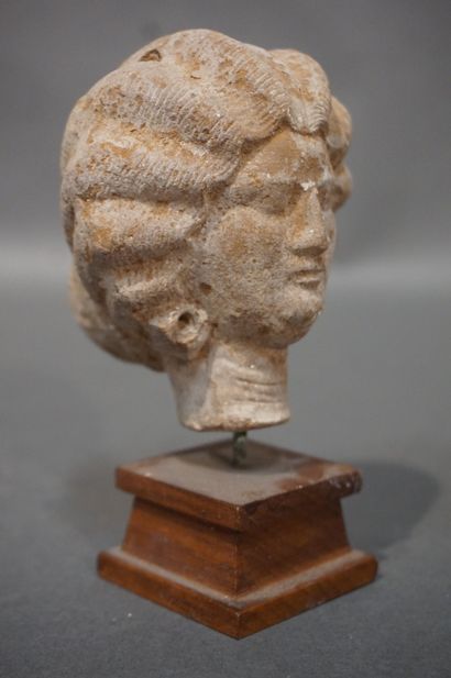 null Female head with a melon-cut hairstyle ending in a bun. Ochre terracotta. Egypt,...