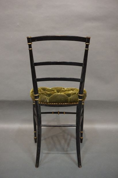 null Quatre chaises en bois laqué noir et doré à assise en velours vert capitonné....