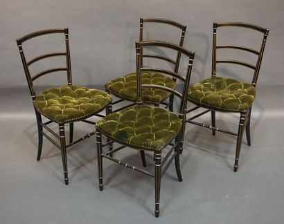 null Quatre chaises en bois laqué noir et doré à assise en velours vert capitonné....