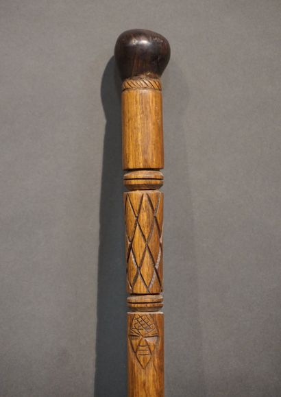 *Bâton Bâton en bois sculpté à décor de masques africains et chevrons. 95 cm