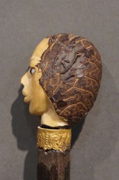*Canne Canne à pommeau figurant une tête sculptée et bague en métal doré. 88 cm