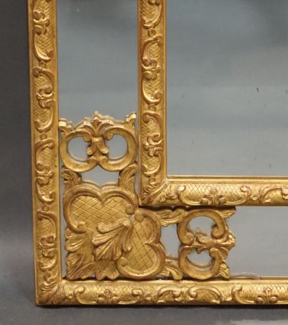 MIROIR Mirror with parecloses and pediment, in gilded and carved wood with flowers...