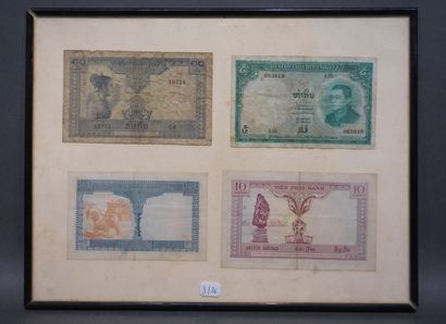 Four framed Vietnamese banknotes.