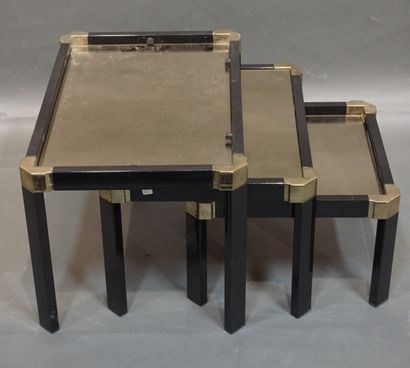 null Trois tables gigognes en métal laqué noir et doré à plateaux miroirs. 37x60,5x40,5...