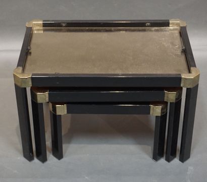 null Trois tables gigognes en métal laqué noir et doré à plateaux miroirs. 37x60,5x40,5...