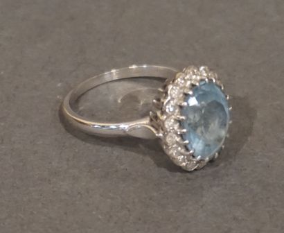 * Bague Bague en or gris sertie d'une pierre bleue clair (aigue - marine?) entourée...