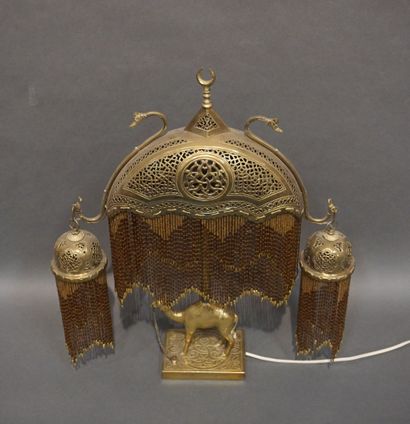 null Lampe orientale en métal doré à décor de dromadaire aux trois abat-jours à pendeloques....