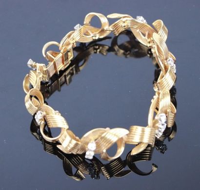 null Bracelet en or jaune formant un ruban cannelé, scandé de diamants ronds taille...
