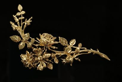 null Broche en métal doré figurant une branche de rosier sur laquelle se pose un...
