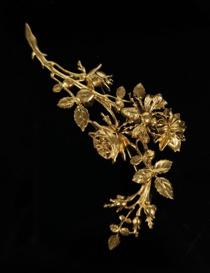null Broche en métal doré figurant une branche de rosier sur laquelle se pose un...